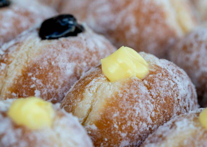 A selection of filled donuts, filled to the brim with custard and jam.